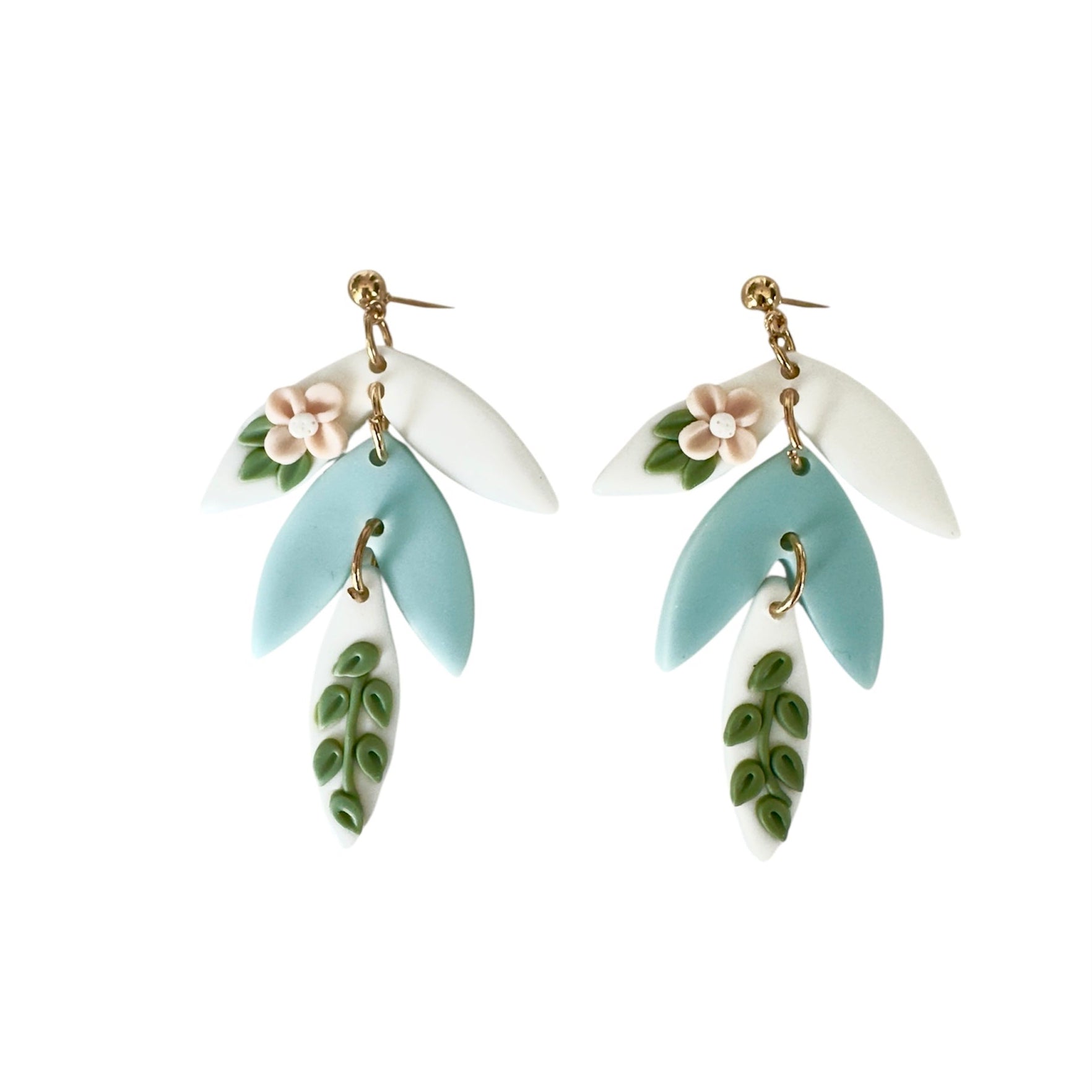 Pair of earrings with floral and leaf designs on a white background