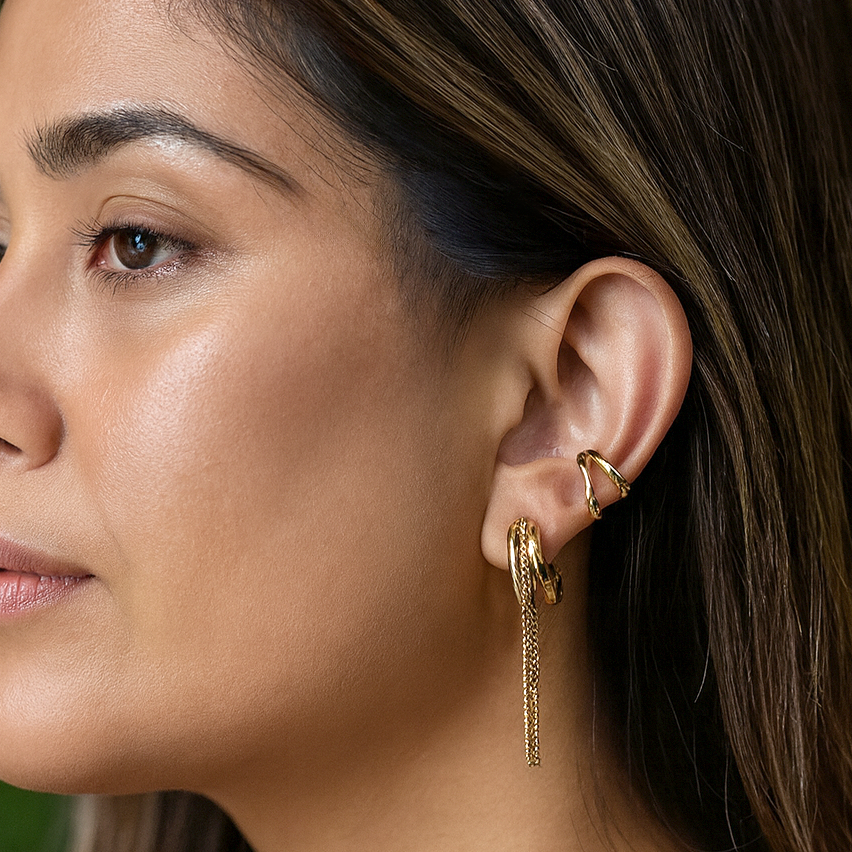 Close-up of a woman wearing gold earrings with a blurred background