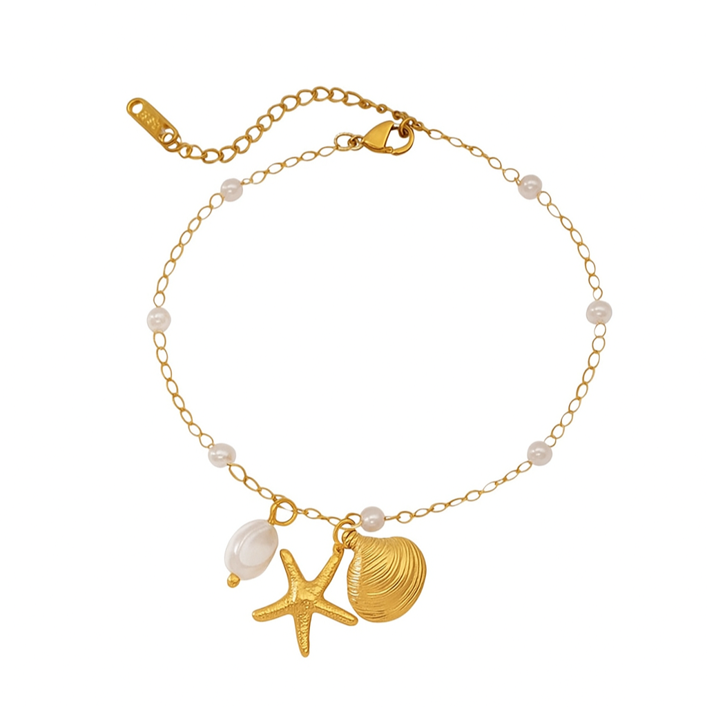 Gold anklet with starfish, shell, and pearl charm on a white background