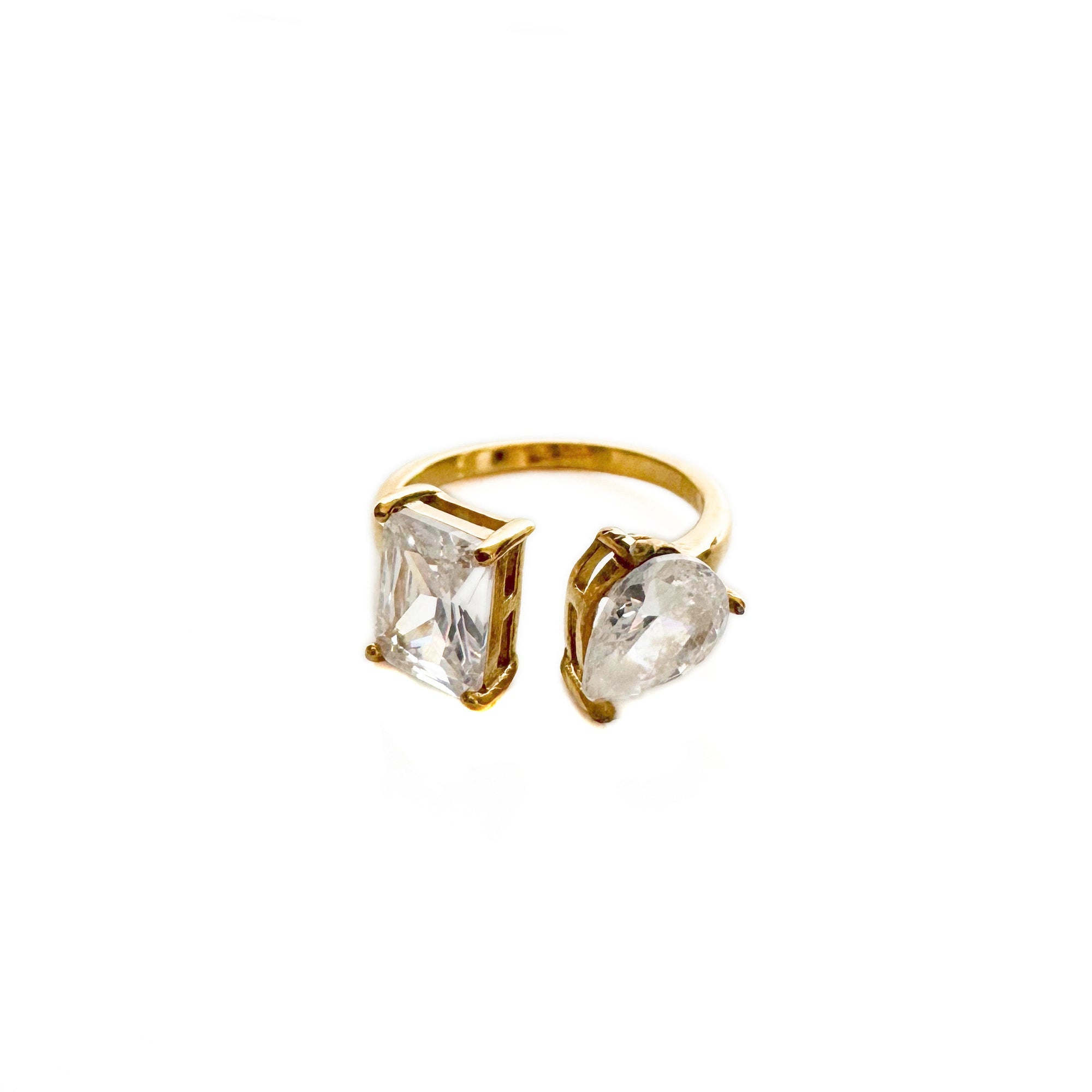 Gold ring with clear gemstones on a white background