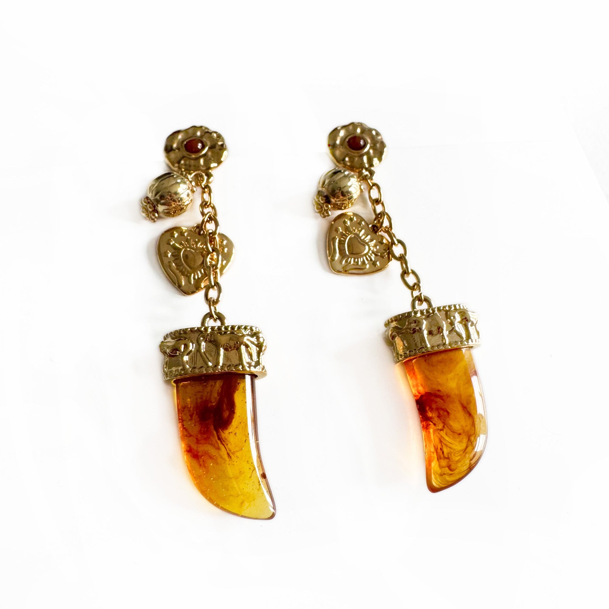 Pair of earrings with amber-colored gemstones and gold accents on a white background