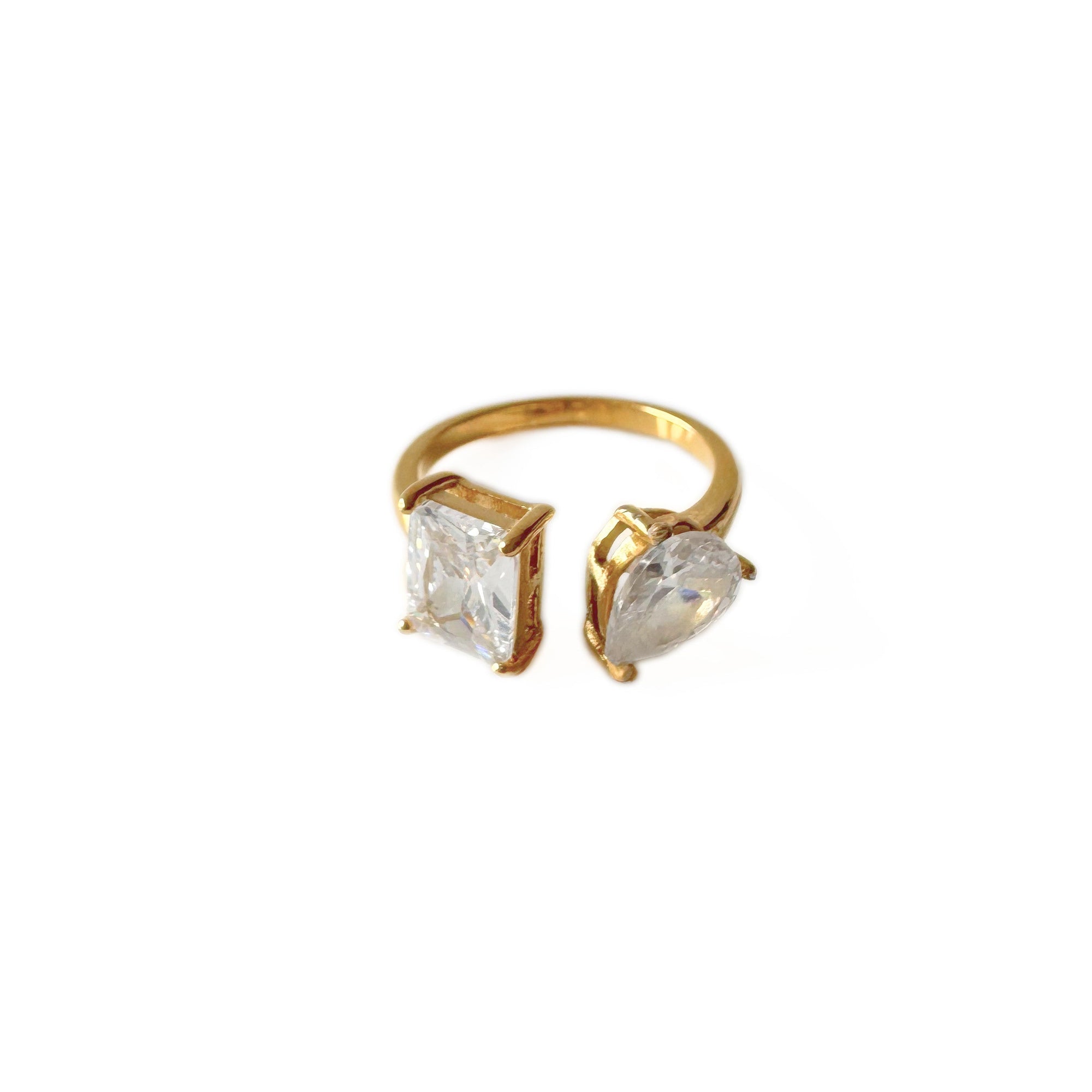 Gold ring with two clear gemstones on a white background