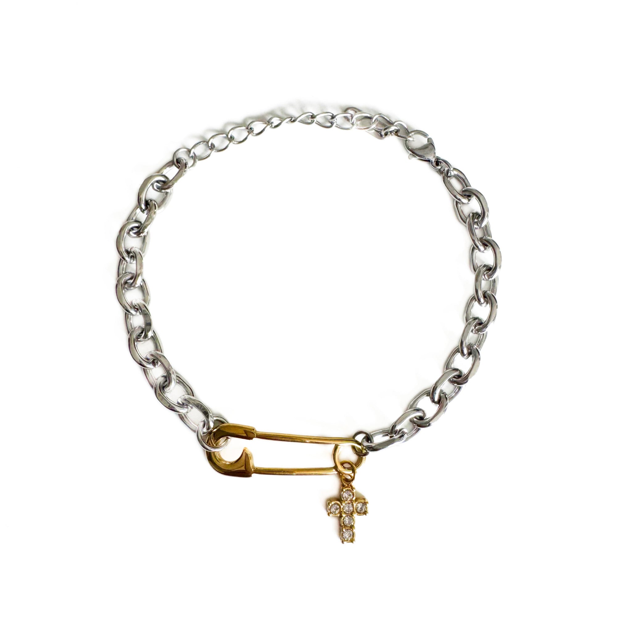 Silver chain bracelet with a gold clasp and cross charm on a white background