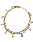 Gold anklet with colorful beads on a white background