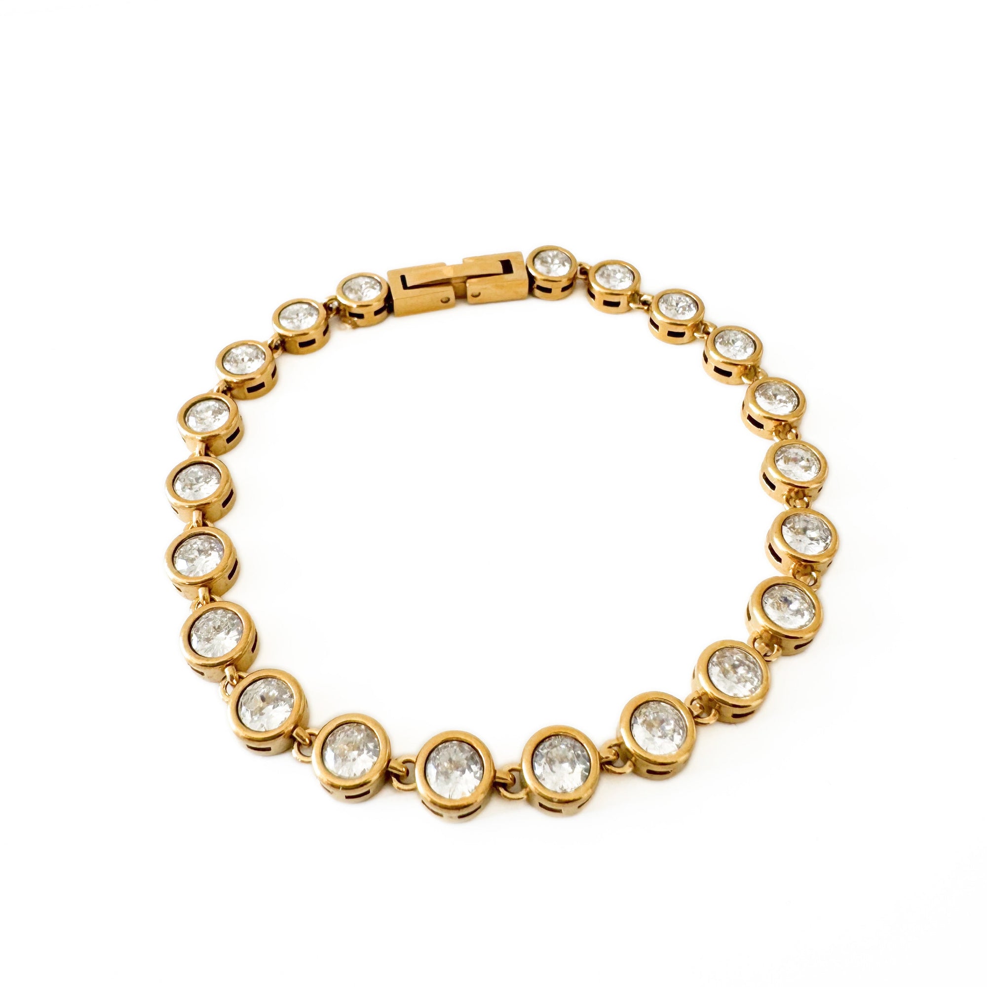 Gold bracelet with clear stones on a white background