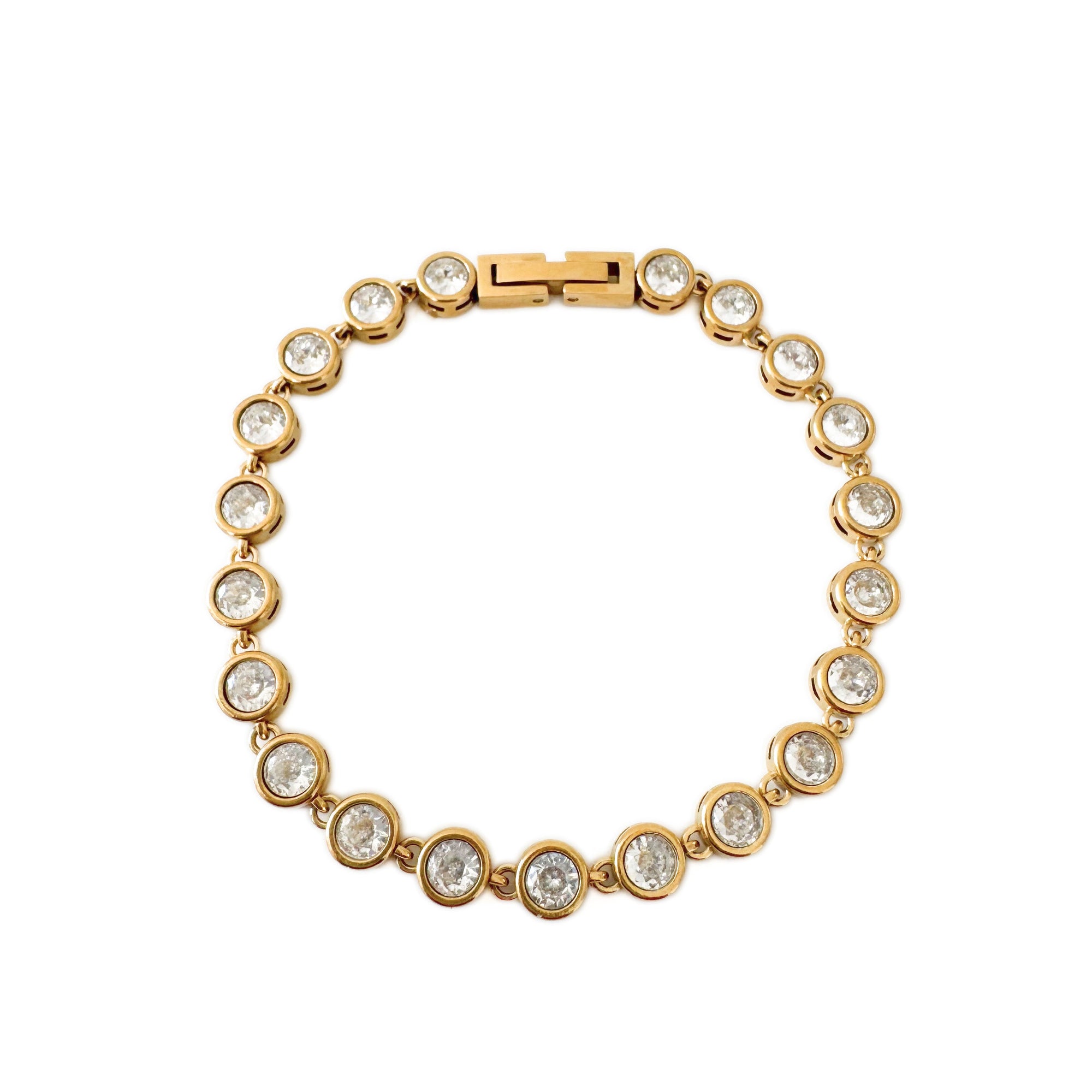 Gold bracelet with clear stones on a white background