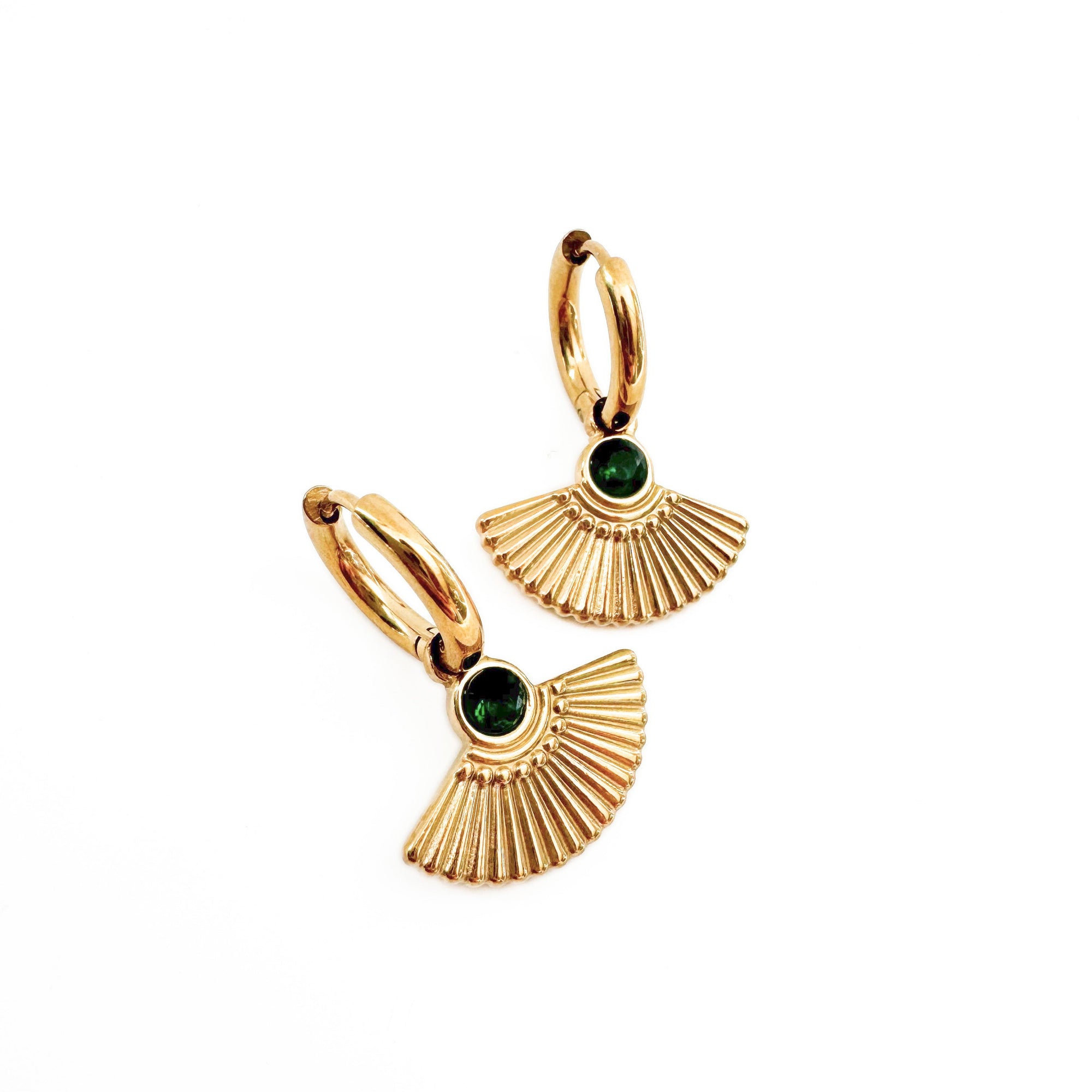 Gold earrings with green gemstones on a white background