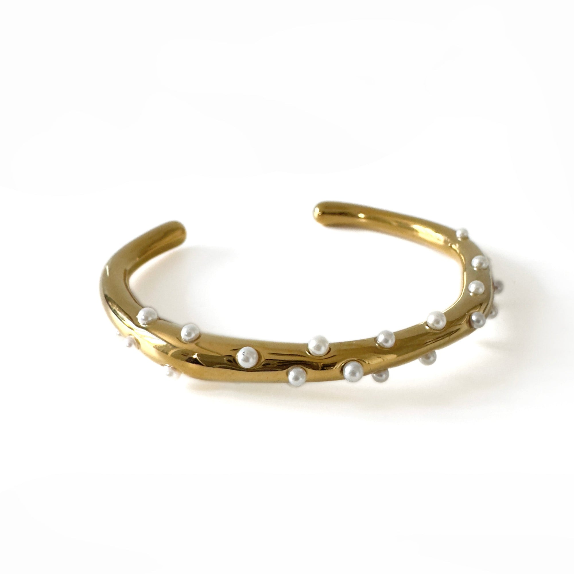 Gold bracelet with pearls on a white background