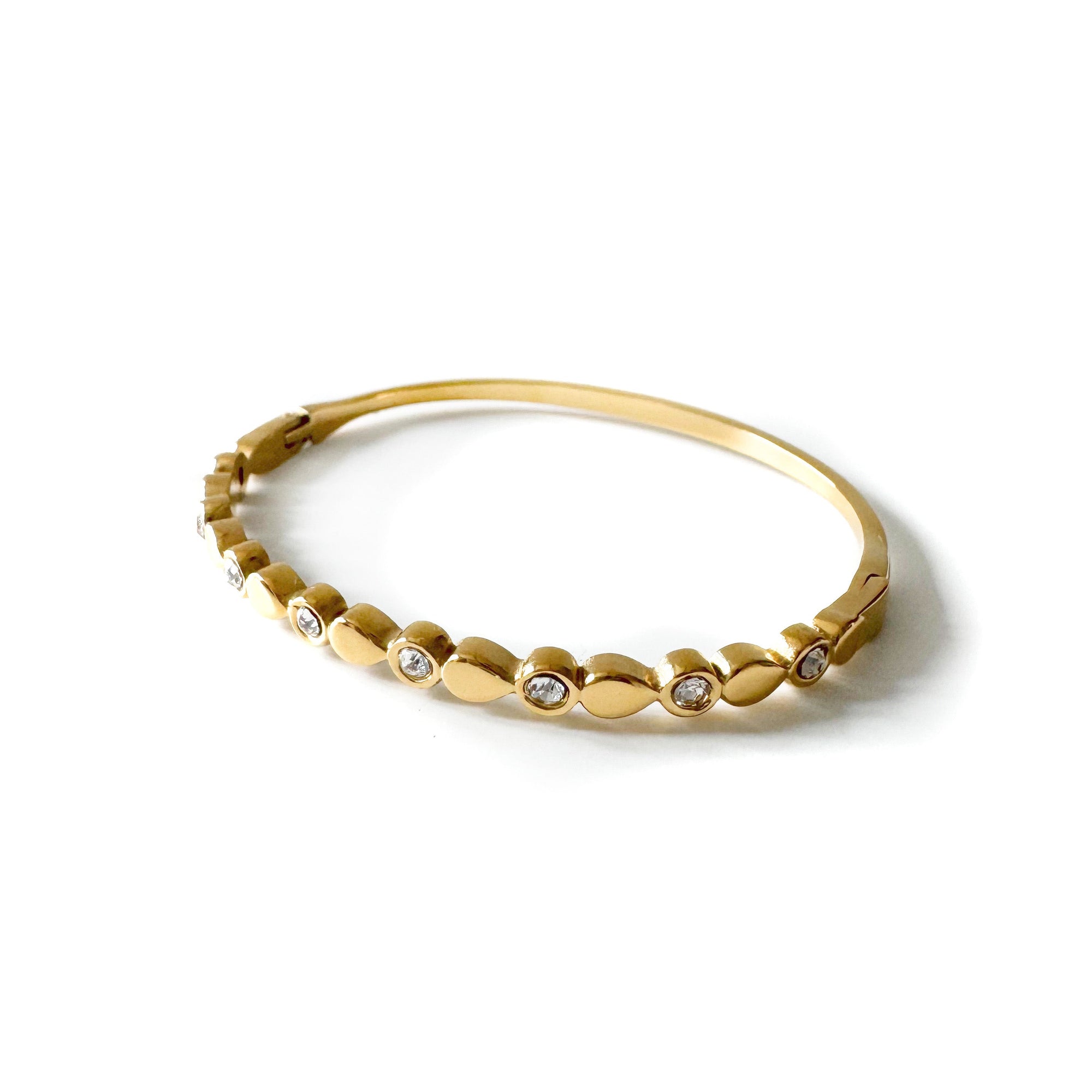 Gold bracelet with small diamonds on a white background