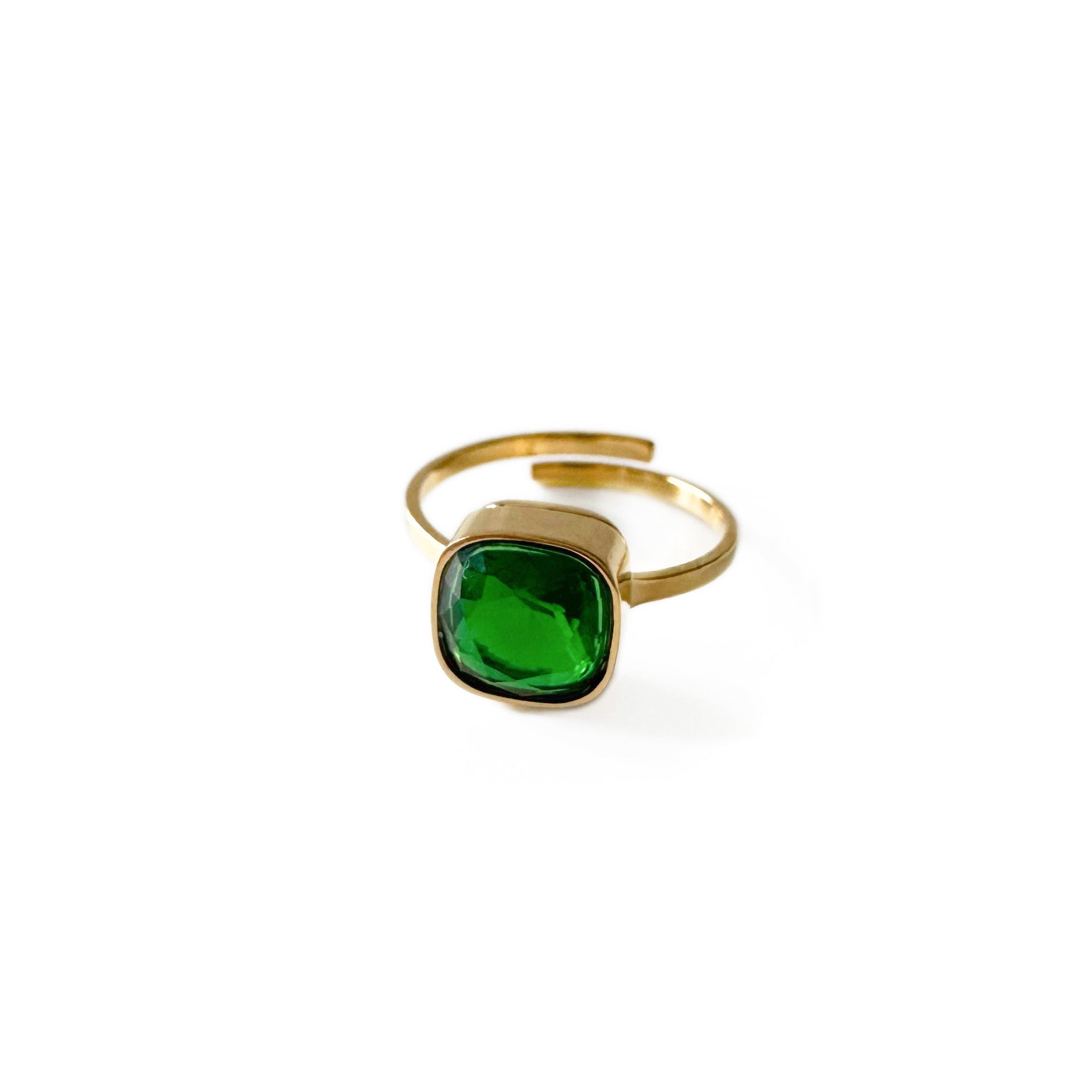 Gold ring with a green gemstone on a white background