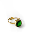 Gold ring with a green gemstone on a white background