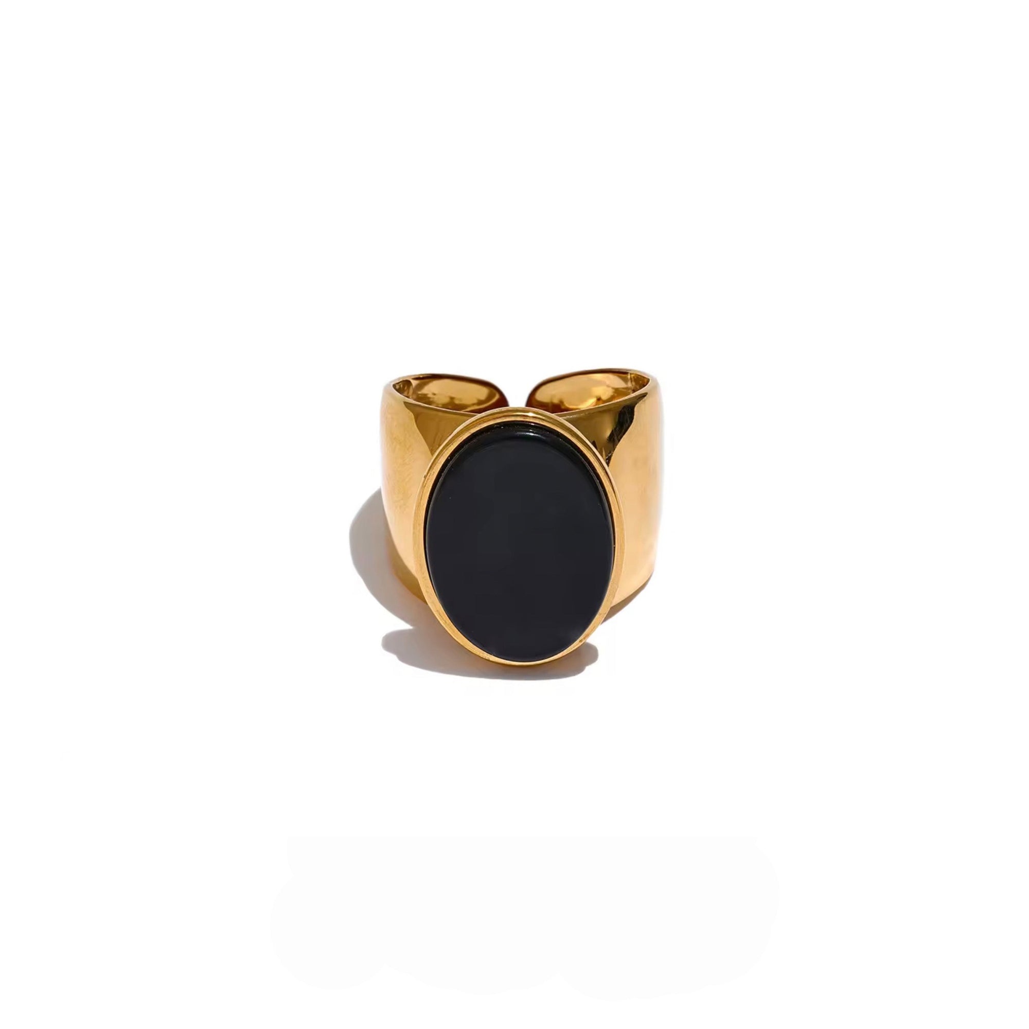 Gold ring with a black stone on a white background